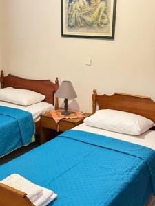 a room with two beds and a lamp on a table at George's & Amalia's appartments 2 in Afantou