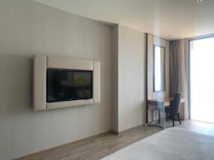 Habitación con TV en la pared y mesa. en Panorama Nha Trang Skydream, en Nha Trang