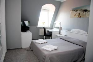 - une chambre avec un lit, un bureau et une fenêtre dans l'établissement Hotel Marina, à Międzyzdroje
