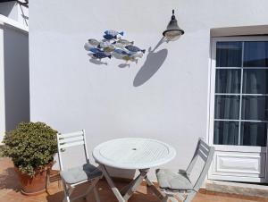 a table and chairs with a table and a lamp at Home2Book Cozy Dúplex & Spacious Terrace in Órzola in Orzola