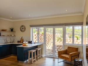 a kitchen with blue cabinets and a table and a chair at Pincushion Heights in Brenton-on-Sea