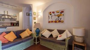 a living room with a couch with pillows on it at Appartamento Emerald in Abbiadori