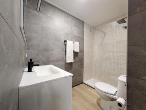 Un baño con un lavabo blanco y un inodoro. en Apartamento en la Playa de Somo., en Somo 51 fotos más