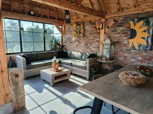 ein Wohnzimmer mit Sofa und Tisch in der Unterkunft Hoeve 203 in Wervik