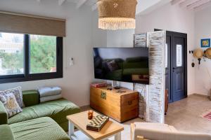 a living room with a couch and a tv at Villa Nomi in Peyia