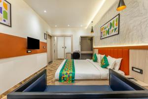 a hotel room with a bed and a tv at Treebo Divine Stay Prayagraj in Prayagraj