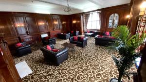 a large room with couches and chairs in a building at Russ Hill Hotel in Charlwood
