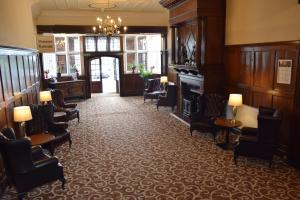 a waiting room with chairs and a piano in a building at Russ Hill Hotel in Charlwood