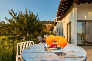 a wooden table with two glasses of orange juice at Villa Nomi in Peyia