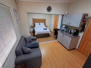 a living room with a bed and a couch in a room at 26onMagazyn in Polokwane