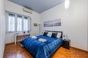a bedroom with a blue bed in a white room at Milano Centro Duomo-Wifi-Metro in Milan