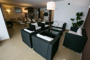 una sala de estar con sillas de mimbre y mesas en un restaurante en Villa Del Mar, en Bari