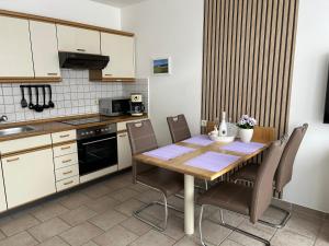 a kitchen with a wooden table and chairs at Ferienwohnung Buhne 33 in Hooksiel