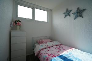 a bedroom with a bed and two stars on the wall at Sea Lavender Holiday Chalet, close to sandy beach in Heacham