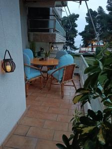 a patio with a table and chairs on a balcony at Four Reasons Apts Kamena Vourla in Kamena Vourla