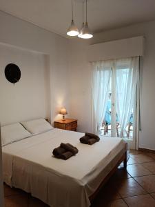 a bedroom with a bed with two towels on it at Four Reasons Apts Kamena Vourla in Kamena Vourla
