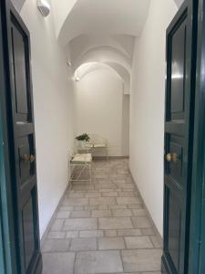 un pasillo vacío con una puerta y una mesa en Residenza Antinori, en LʼAquila