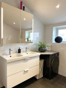 a bathroom with two sinks and a washing machine at Apartment close to central city in Gothenburg +48 photos