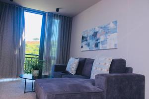 a living room with a couch and a table and a window at Zimbali lakes boulevard edge 214 in Ballito +13 photos