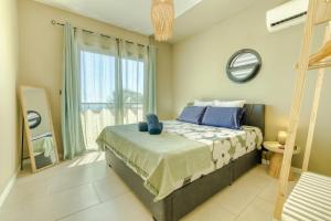 una camera da letto con un letto e una grande finestra di VILLA ANDALOUSIA - 8 Voyageurs a Saint-Leu