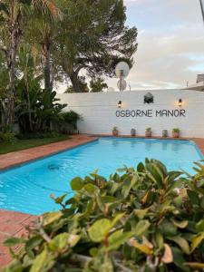 a blue swimming pool with a sign that reads osborne mirror at Osborne Manor Luxury Guesthouse in Kimberley