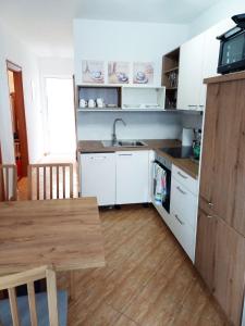 ボドニャンにあるApartment Tinaのキッチン(白いキャビネット、テーブル、シンク付) +4枚の写真