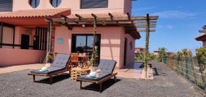 two chairs and a table in front of a house at Villa Macaronesia Lajares Fuerteventura Remote work in Majanicho