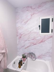 a white bathroom with a pink marble wall at Casa rosa completa-patio- BBQ-columpios-buhardilla in Campillo de Altobuey +11 photos