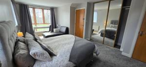 een slaapkamer met een bed, een stoel en een spiegel bij Alexandra Park Town House 223 in Belfast