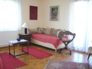 a bedroom with a bed with a red blanket and a table at Alba Apartments in Banjole