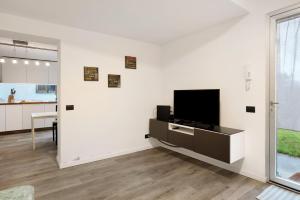 a living room with a flat screen tv on a white wall at Gli Ulivi in Santo Stefano di Magra