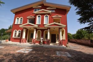 czerwony dom z hydrantem pożarowym przed nim w obiekcie Villa Parco del Monte w mieście Cassano Jonio +1 zdjęcie
