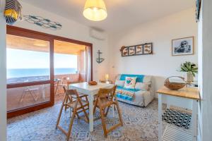 a living room with a table and chairs and a couch at Il Belvedere Di Achille in Costa Paradiso
