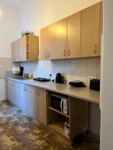 una cocina con armarios de madera y microondas en una encimera en Hostel Uno No Alkohol-Only Comfort, en Cracovia