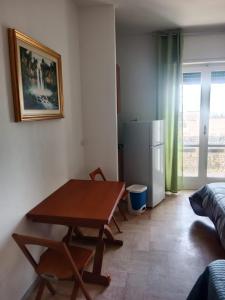 a kitchen with a wooden table and a refrigerator at Manzoni in Altamura