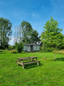a picnic table and a house in a field at Les trois bergers in Serley