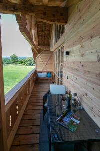 un porche de una cabaña de madera con mesa y sillas en Ferienwohnung Schmickhof, en Gaißach