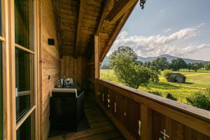 - Balcón de cabaña con vistas a una granja en Ferienwohnung Schmickhof, en Gaißach