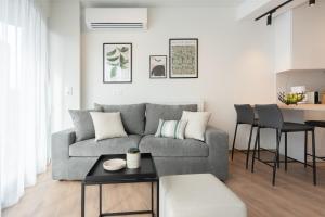 a living room with a gray couch and a table at Silk Athens Urban Collection in Athens