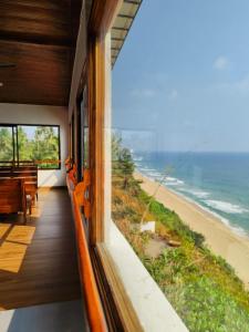 a room with a view of the beach and the ocean at Peak Paradise Resort in Varkala