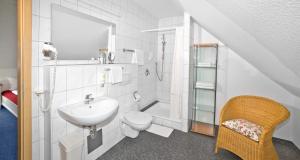 a white bathroom with a sink and a toilet at Fairway Hotel in Sankt Leon-Rot