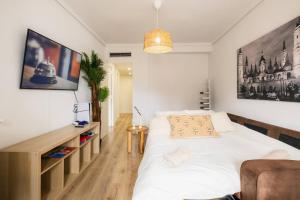 une chambre avec un grand lit blanc et un bureau dans l'établissement Casa Jesús PS5 Juegos Niños WiFi 6 Pax, à Saragosse