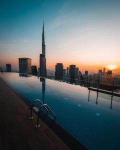a swimming pool on top of a building with a city skyline at Paramount Hotel Midtown in Dubai