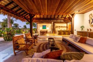 an outdoor living room with a couch and a fireplace at VILLA COLIBRI Guriú in Guriú