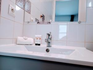 ein weißes Badezimmer mit Waschbecken und Spiegel in der Unterkunft Studio Beau Soleil in LʼIsle-sur-la-Sorgue + 17 Fotos