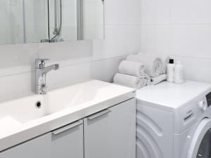 Un baño blanco con lavabo y lavadora. en Henniina V Pakkahuone II - City Center - Free Parking, en Oulu 6 fotos más