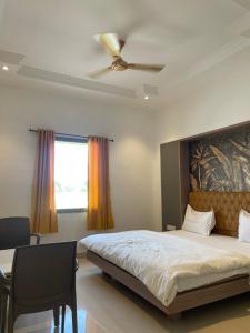 une chambre avec un grand lit et une fenêtre dans l'établissement Mannat Resort, à Bikaner