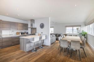 a kitchen and dining room with a table and chairs at 118 Lower Mill Estate - Sleeps 12 Villa with Lake Views in Somerford Keynes