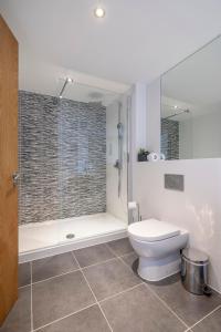 a bathroom with a toilet and a glass shower at 118 Lower Mill Estate - Sleeps 12 Villa with Lake Views in Somerford Keynes