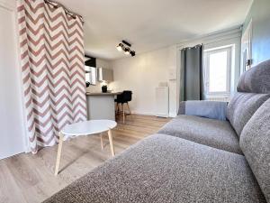 a living room with a couch and a table at Au nid du clos cocon a la campagne 10min de Reims in Courcelles-Sapicourt